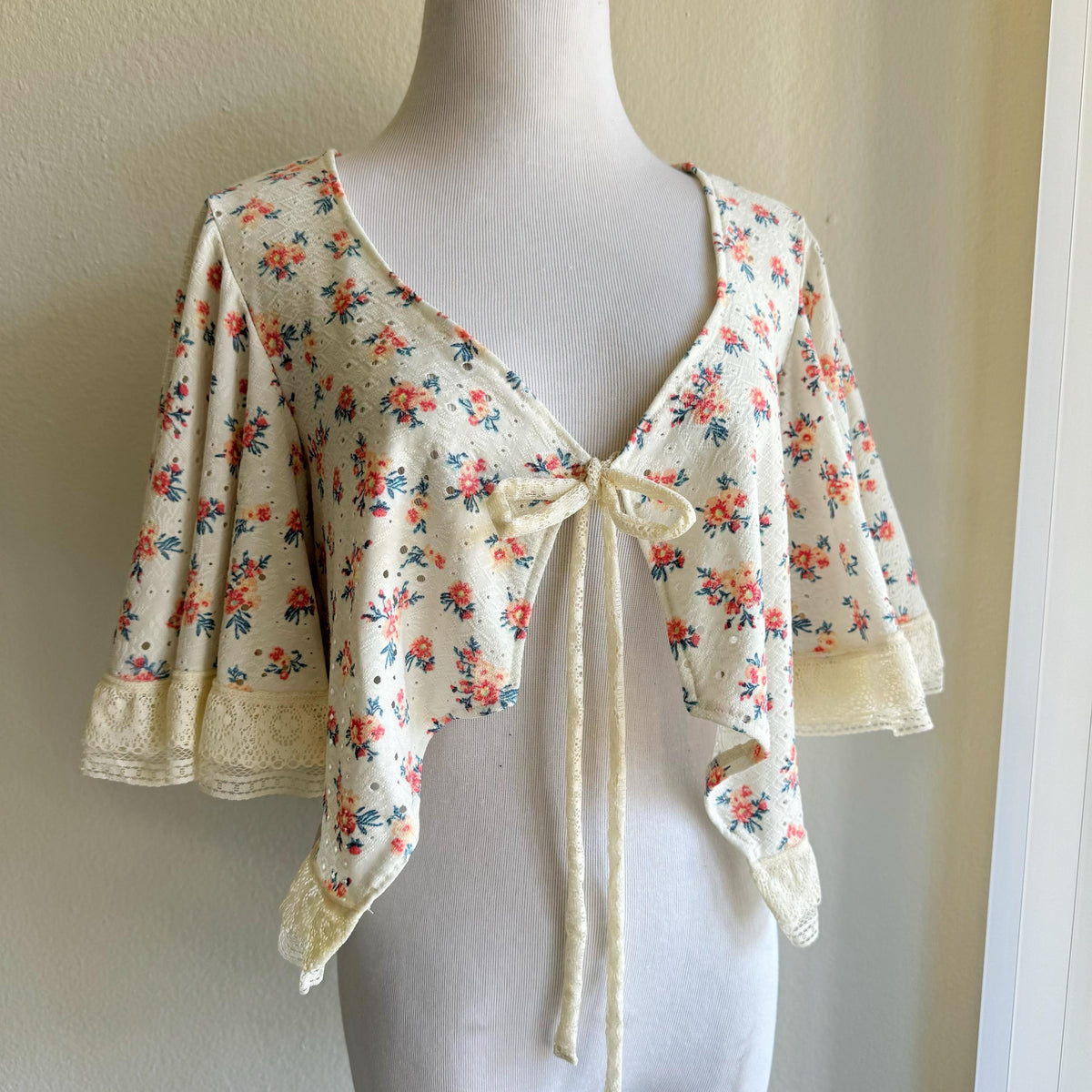 Floral patterned top on a mannequin against a plain background