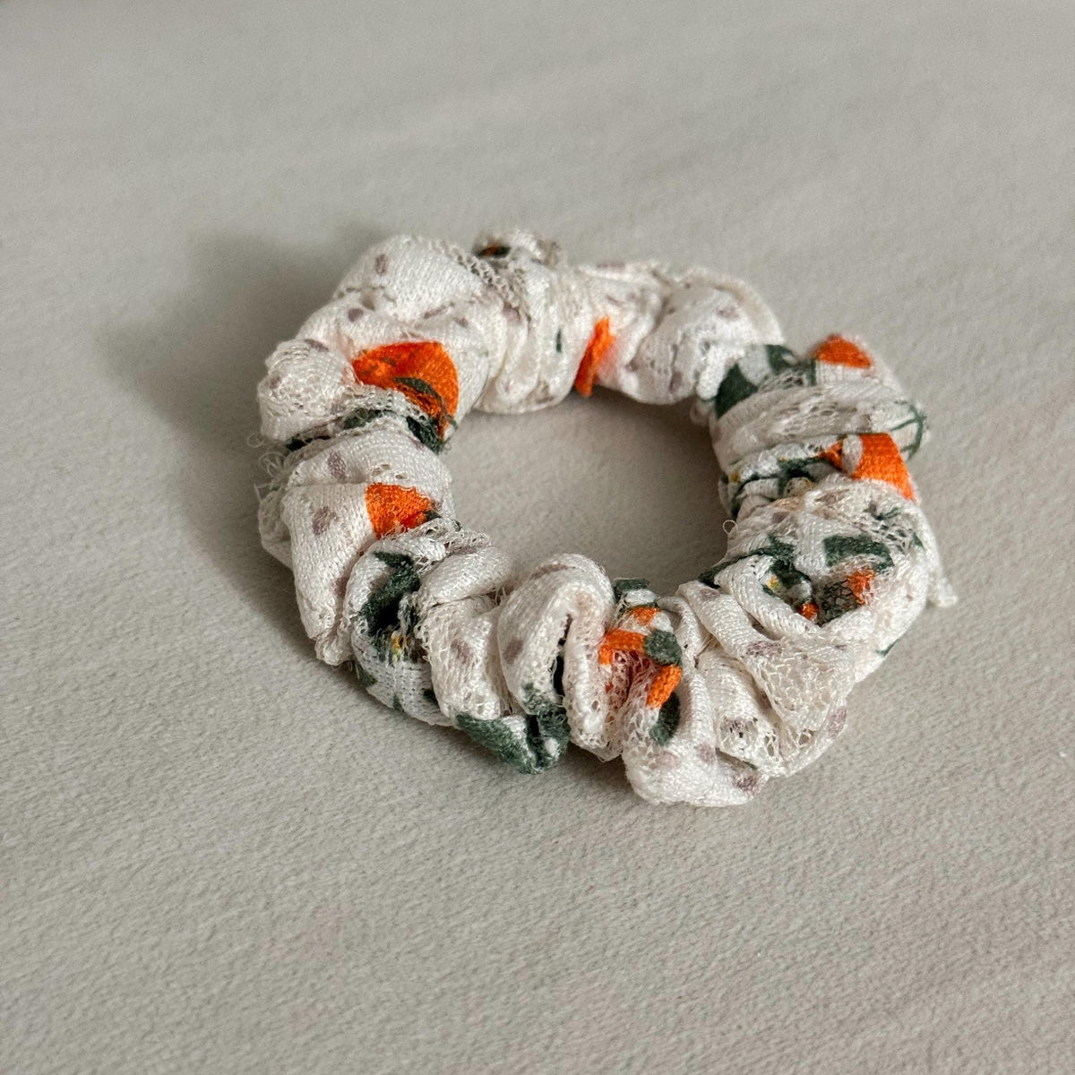 Scrunchie with floral pattern on a light gray surface
